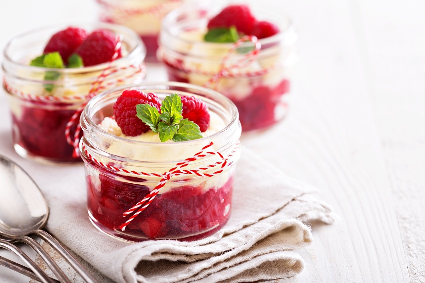Berry crumble dessert with cream sauce in small jars